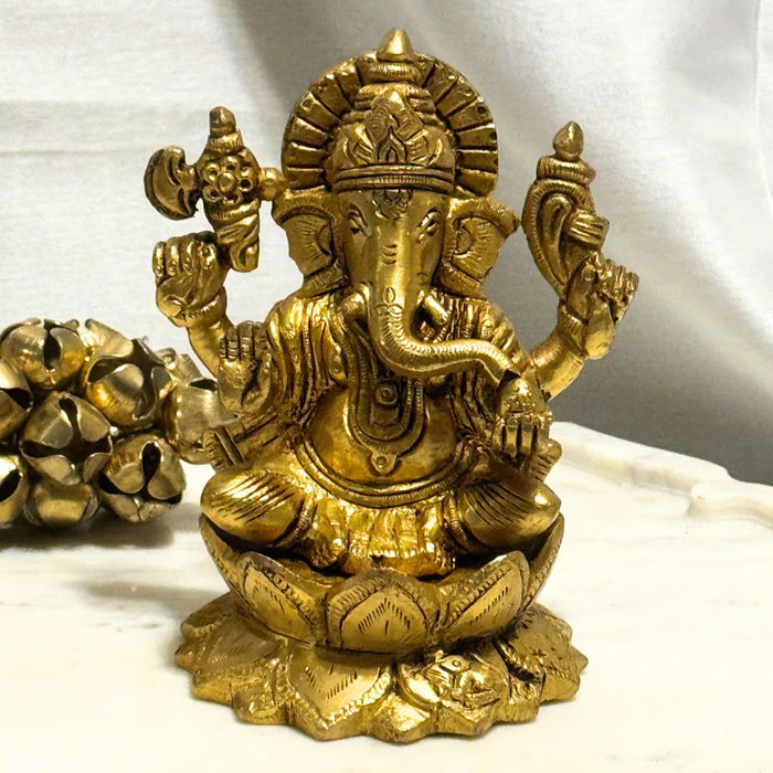 Gold-colored statue of a deity on a white marble surface