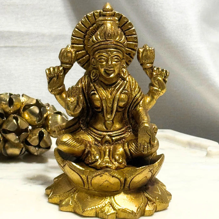 Gold-colored statue of a deity on a white background