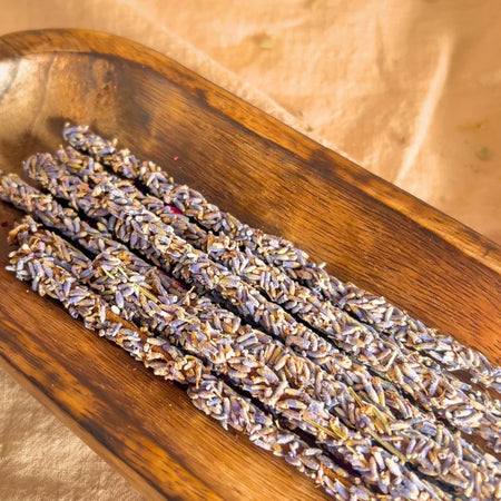 Three bundles of lavender on a wooden tray with a soft, blurred background