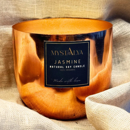 Copper candle holder with a label on a textured fabric background