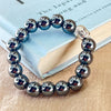 Silver beaded bracelet with Buddha charm on a book