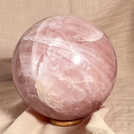 Pink crystal sphere on a beige surface