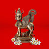 Bronze statue of a winged bull with flowers on a red background