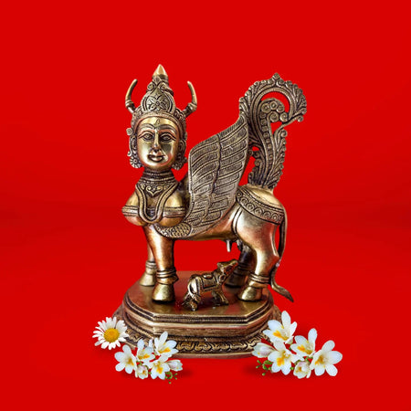 Bronze statue of a winged bull with flowers on a red background