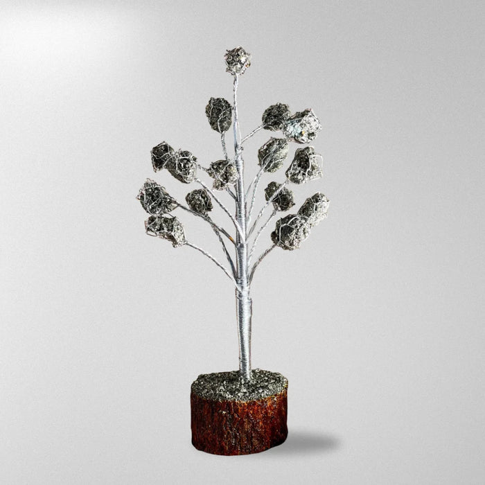 Decorative silver tree branch with a brown base on a light gray background